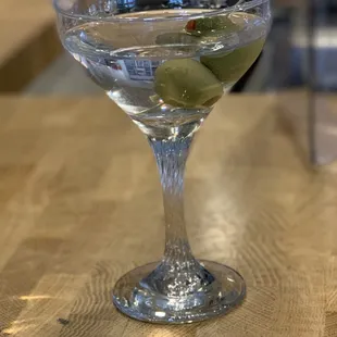 a martini glass with olives in it