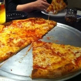 a pizza on a pan with a slice taken out of it