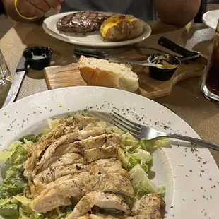 Cesar salad with chicken, across ribeye and loaded potato.