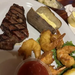 Steak and fried shrimp and baked potato with cocktail sauce Cattlemen Traditional
