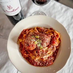 a plate of pasta and a bottle of wine