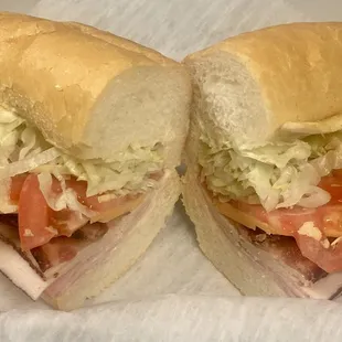 Club Sandwich with ham, turkey, bacon, cheddar, lettuce, tomato and mayo on Dong Phuong pistolette