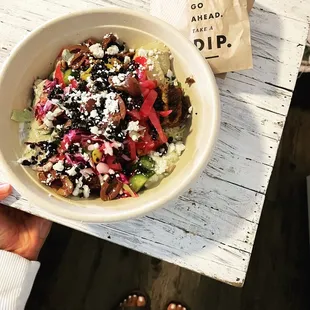 a person holding a bowl of food