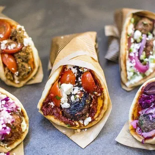 a variety of burritos on a tray