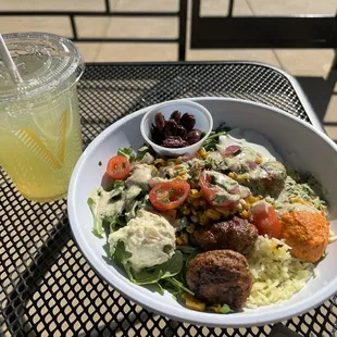 Lamb meatballs, arugula, Bismati rice, feta, tomatoes/red onion, tzatziki sauce .. that&apos;s all I remember. Cucumber lime drink!