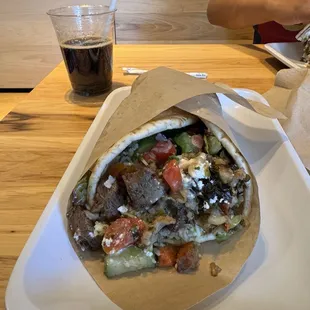 pita with tzatziki spread, grilled steak, tomatoes, and cucumbers. Finishing it off with feta cheese, lemon herb tahini, and yogurt dill.