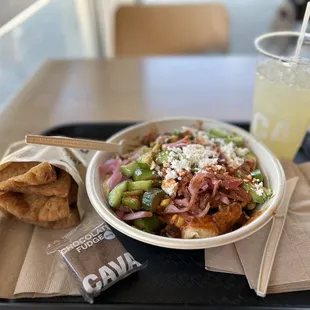 a bowl of food and a drink on a tray