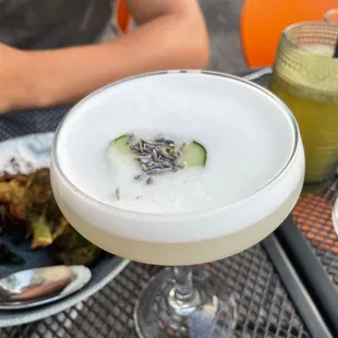 a cocktail with a cucumber garnish