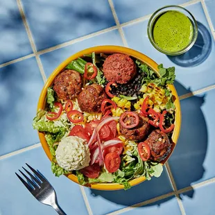 a bowl of salad with meatballs and vegetables