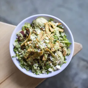 a bowl of broccoli salad on a wooden table