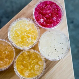 four different types of jellys on a wooden table