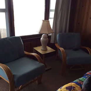 Chairs inside oceanfront rooms. Window looks out onto ocean.