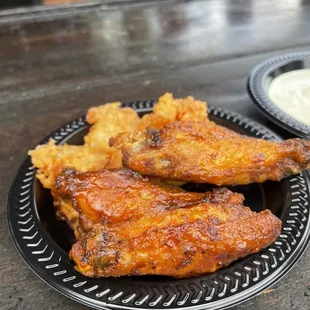 a plate of chicken wings and a bowl of ranch dip