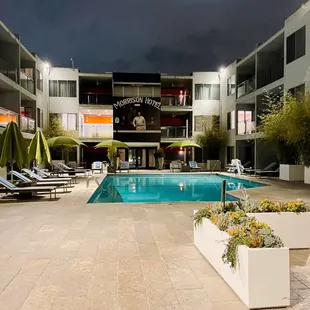 a pool and lounge chairs at night
