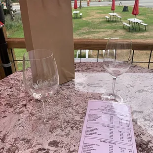 a wine glass and menu on a table