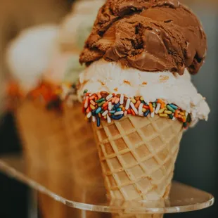 three ice cream cones with sprinkles