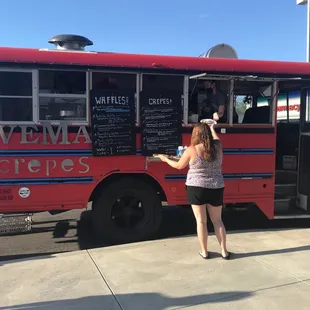 a woman standing in front of a food truck
