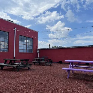 picnic tables in front of a red building
