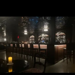 a dimly lit bar with chairs