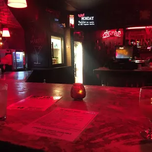 a dimly lit bar with red lights