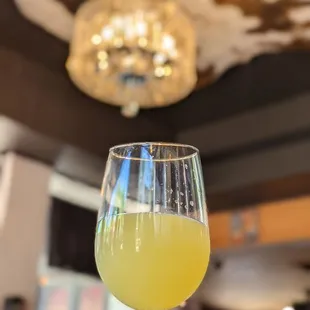 a hand holding a glass of orange juice
