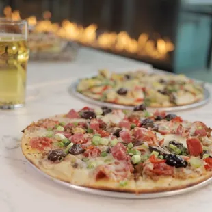 three pizzas and a glass of beer