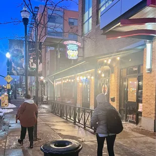 two people walking down the sidewalk