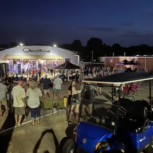 a crowd of people standing around a golf cart