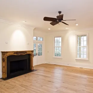 empty living room with fireplace and fan