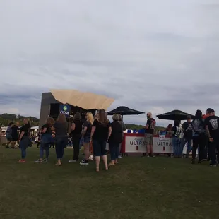 a crowd of people standing in front of a tent