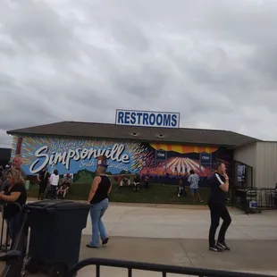 Bathrooms on both sides, one side has a mural painted on them.