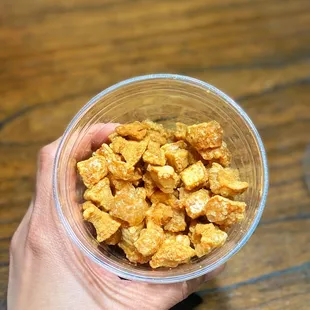 a hand holding a cup of cereal