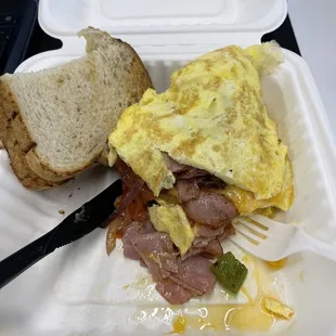 Inside a Denver omelette. Ham, bell pepper, onions, tomatoes. With a side of sourdough toast.