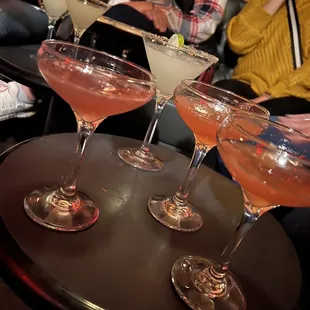 a table with four cocktails on it