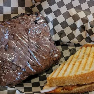 A GIANT brownie and half of a Buffalo chicken panini