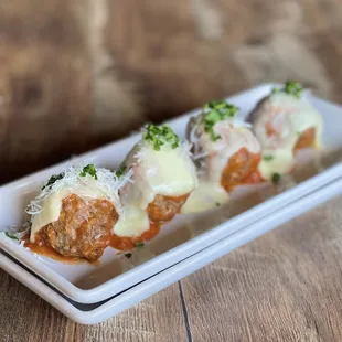 a plate of meatballs with cheese and sauce