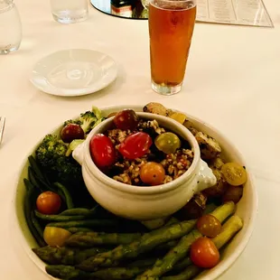 a bowl of vegetables and a glass of beer
