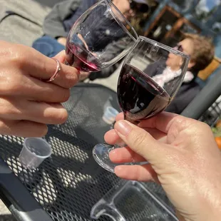 two people toasting wine glasses