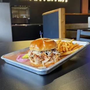 Smoked tender chicken in mild bbq sauce served with our signature sandwich slaw on a toasted bun. Your choice of side.