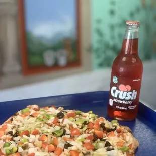 a pizza and a bottle of soda