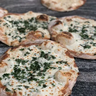 four homemade pizzas on a table