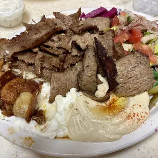a plate of meat, mashed potatoes, and vegetables