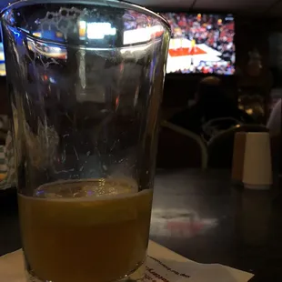 a glass of orange juice on a napkin