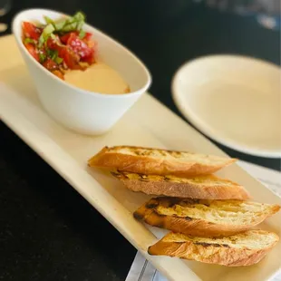 a plate of bread and a bowl of dip
