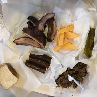 Friday trifecta spread- ribs, sausage, brisket. Comes with cheese, bread, pickles/onions. No beans or potato salad.