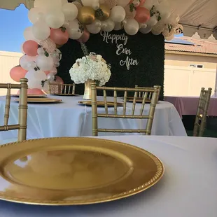 Tables, Chiavari chairs, linens, charger plates, hedge wall and custom balloon garland with wood cutout