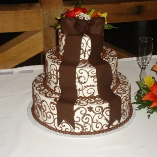 Chocolate scrolls and fondant bow adorn this fall wedding cake.