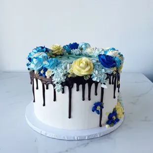 White buttercream base with a chocolate drip.