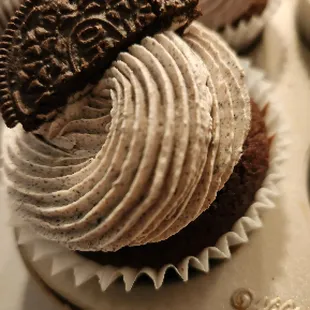 a chocolate cupcake with a cookie on top