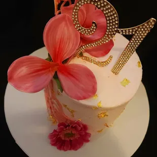 Here's a 21st birthday treat fit for royalty - layers of vanilla buttercream, accented with shimmering gold flakes and wrapped in pink white